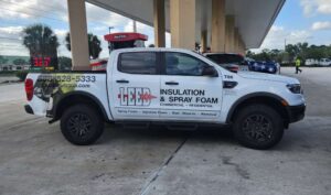 LEED Insulation work truck parked at gas station