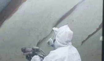 Installer applying spray foam insulating to an attic space.